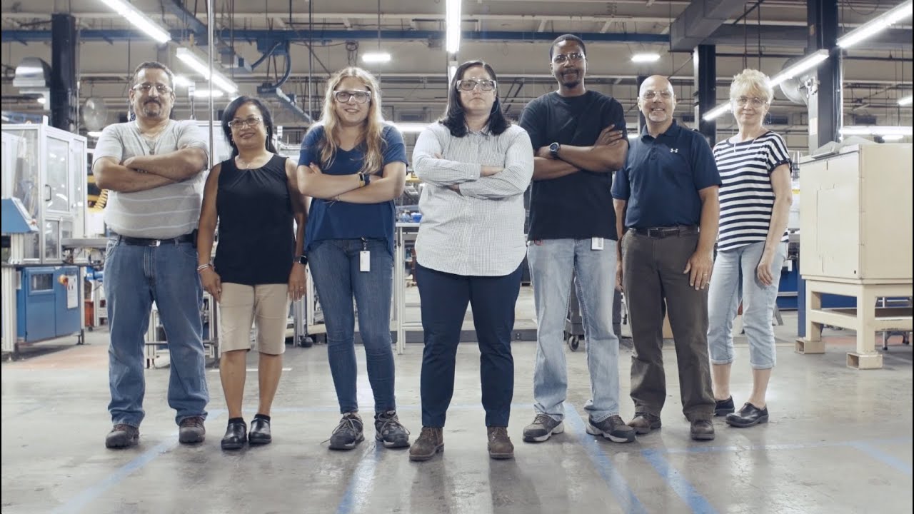 Team members on a manufacturing floor during a shift briefing